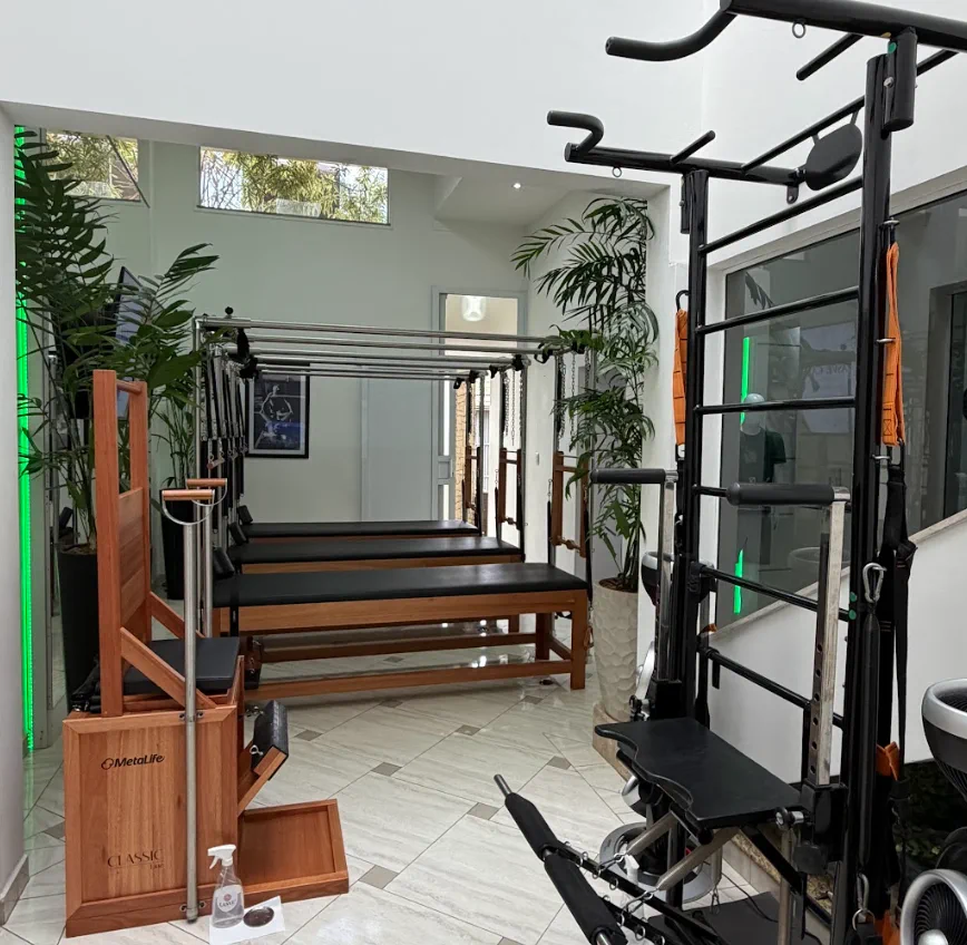 Equipamentos de pilates em ambiente claro e cercado por plantas
