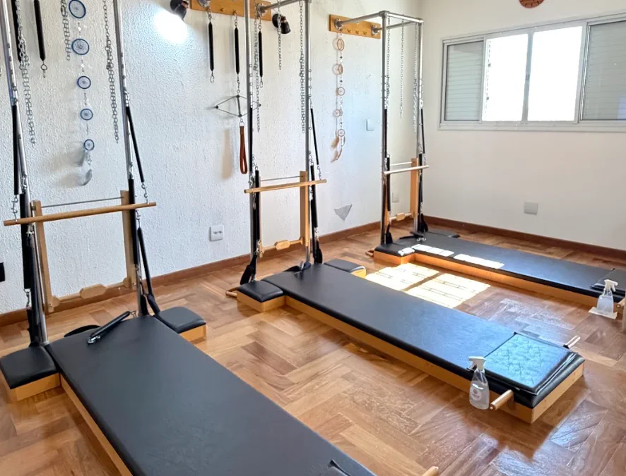 Sala de pilates com aparelhos junto à janela