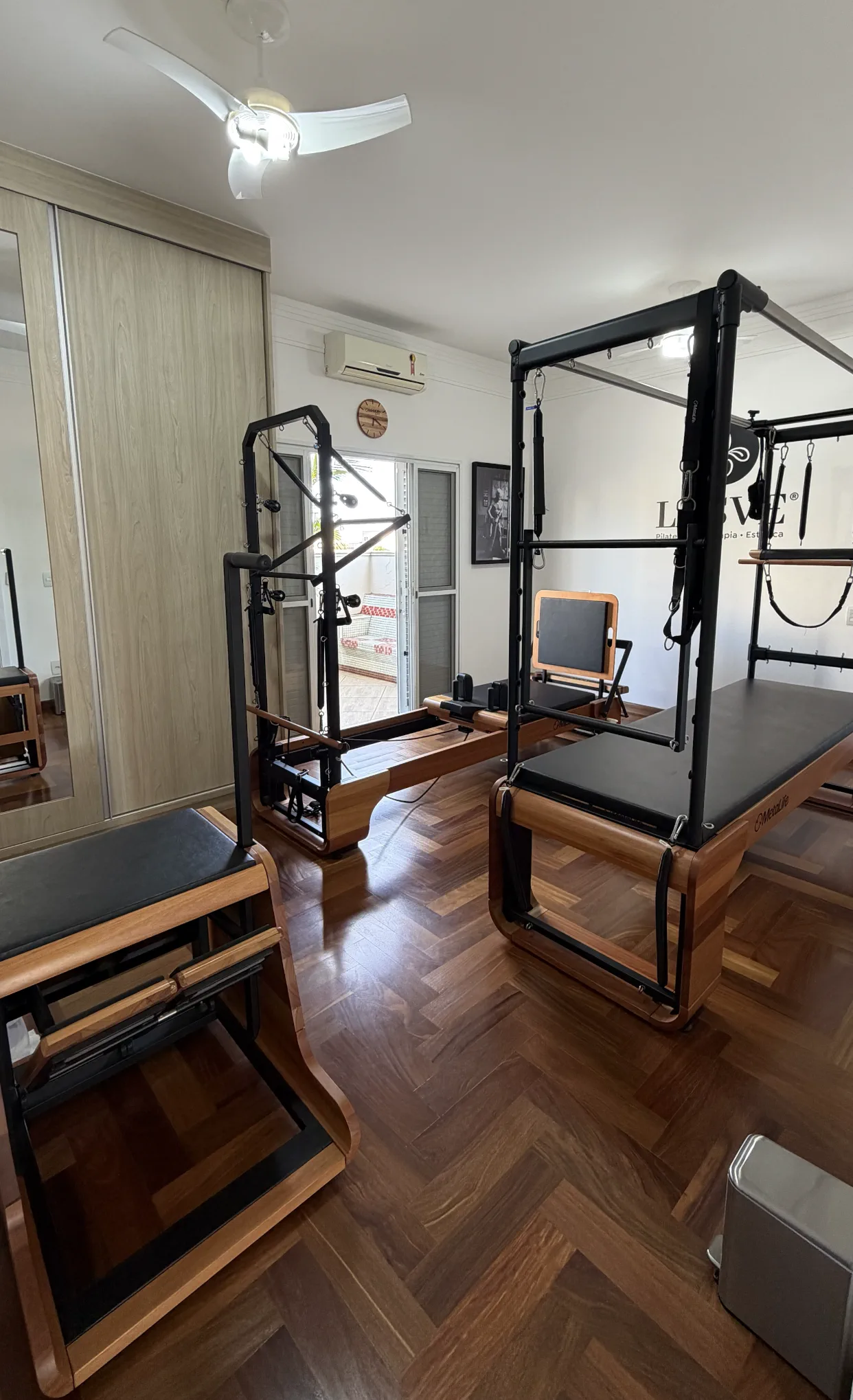 Sala iluminada da LASVE com aparelhos de pilates em madeira e luz natural